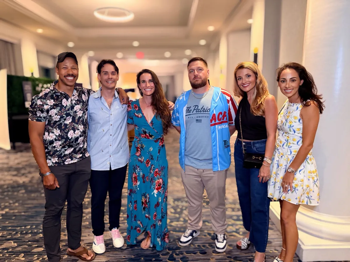 Six creators posing together in a hotel hallway at MIC 2026.